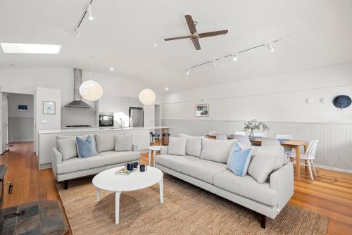 a living room with a couch and a table at Swyn Y Mor Riverside Cottage Haven in Ocean Grove