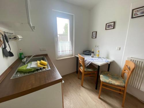 a kitchen with a sink and a table and a table and chairs at Ferienwohnung Felix in Templin