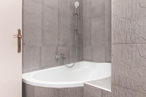 a shower with a white tub in a bathroom at Apartment Hani Koper in Koper