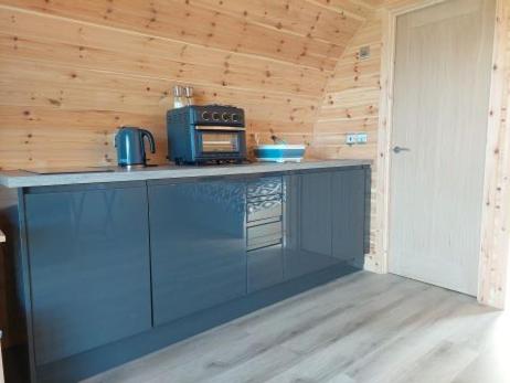 a kitchen with a counter with a microwave and a stove at High Whashton Springs Glamping Pod, Richmond Yorks in Richmond