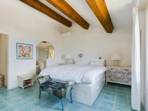 sypialnia z białym łóżkiem i niebieskimi podłogami wyłożonymi kafelkami w obiekcie Villa Paloma St Tropez w Saint-Tropez