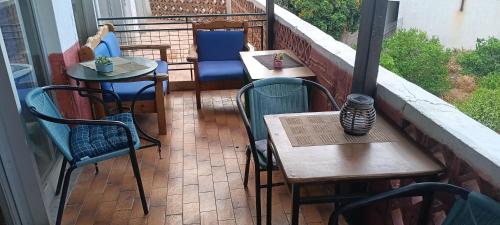 a patio with tables and chairs on a balcony at Hotel zakros rooms-restaurant in Zákros