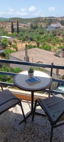 a table and chairs on a balcony with a view at Hotel zakros rooms-restaurant in Zákros