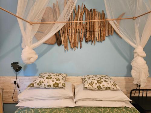 Bett mit Vorhängen und Kissen in einem Zimmer in der Unterkunft VILLA VILLACOLLE in Procchio