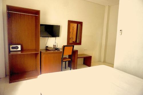 a bedroom with a bed and a desk with a computer at Diva Lombok Resort in Senggigi 
