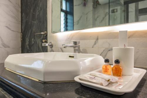 a bathroom counter with a sink and a mirror at Pallavi International in Kolkata