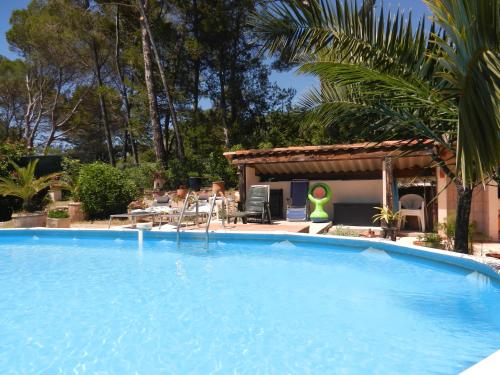 a large blue swimming pool next to a house at L'Oliveraie in Draguignan