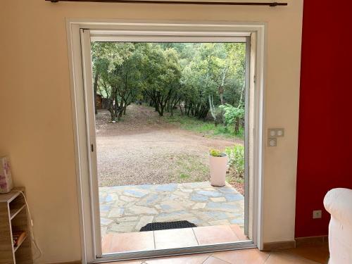 une porte ouverte avec vue sur la cour dans l'établissement Maison dans la garrigue, à Beaulieu