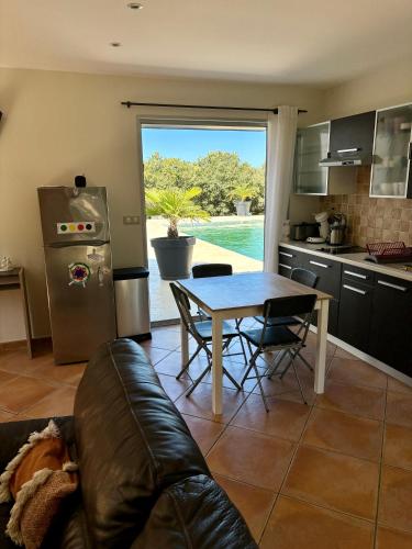 un salon avec une table et une cuisine dans l'établissement Maison dans la garrigue, à Beaulieu