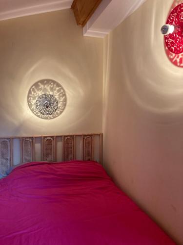 - une chambre avec un lit violet et deux lumières dans l'établissement Maison dans la garrigue, à Beaulieu