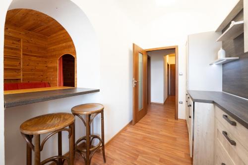 a kitchen with two stools and a counter in a room at EA Horský Hotel Hájenka in Modrava