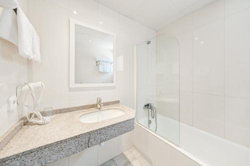 Baño blanco con lavabo y espejo en Apartamentos Vista Club en Santa Ponsa