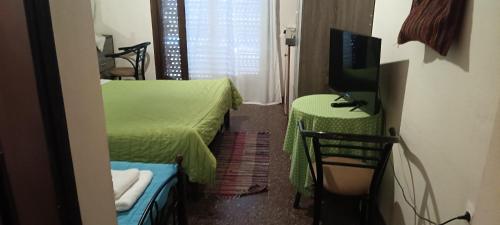 a small room with two beds and a television at Hotel zakros rooms-restaurant in Zákros