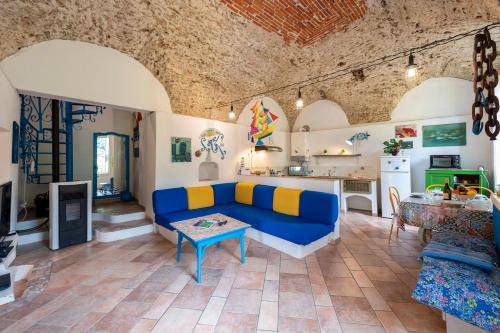 uma sala de estar com um sofá azul e uma cozinha em Villa Sara - 5 Min From The Sea - Happy Rentals em Finale Ligure