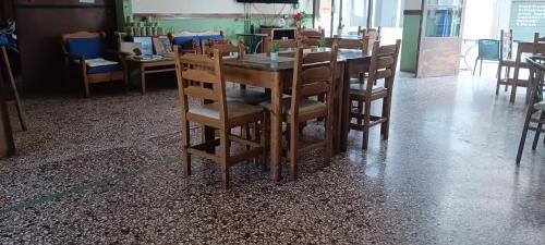 a wooden table and chairs in a dining room at Hotel zakros rooms-restaurant in Zákros