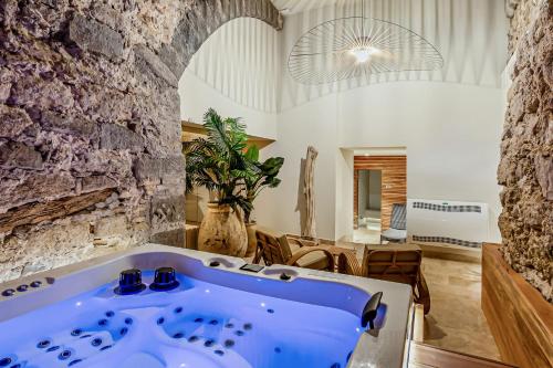 a bath tub in a room with a stone wall at Château Hermitage de Combas in Servian