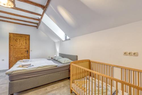 sypialnia z łóżkiem i drewnianym łóżeczkiem dziecięcym w obiekcie Bajsova domačija w mieście Podčetrtek
