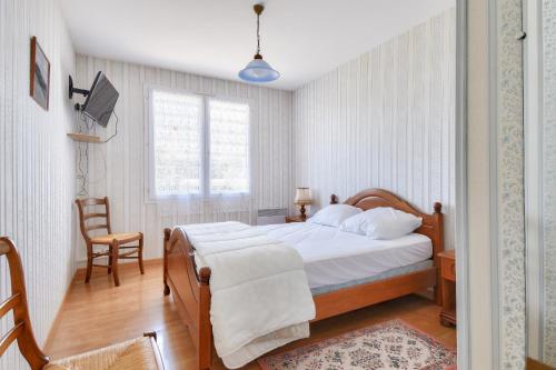 a bedroom with a bed and a chair and a television at Maison familiale pour 8 a 750m de la plage in Brétignolles-sur-Mer