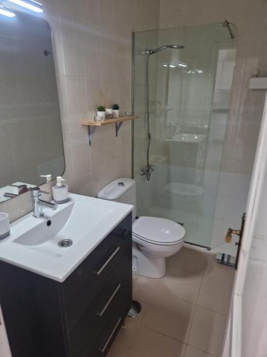 a bathroom with a sink and a toilet and a shower at Apartamento con maravillosas vistas en primera línea in La Restinga