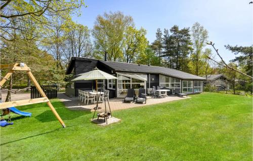 a house with a playground in the yard at Awesome Home In Glesborg With Kitchen in Fjellerup Strand