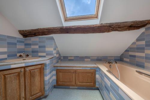 a bathroom with blue tiles and a sink and a tub at À 400m des marais de Guérande - Maison de paludier in Kermoisan