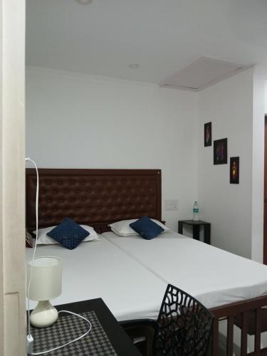 um quarto com uma grande cama branca com almofadas azuis em annies inn homestay em Cochin