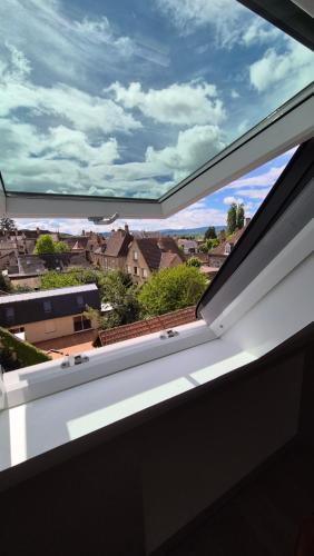 a window with a view of a city at L'Arbre Voyageur in Autun