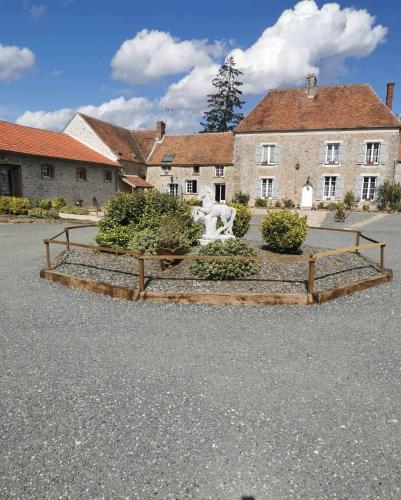 a building with a statue in the middle of a parking lot at Domaine de la Ferme de Jean Grogne in Fontenay-Trésigny