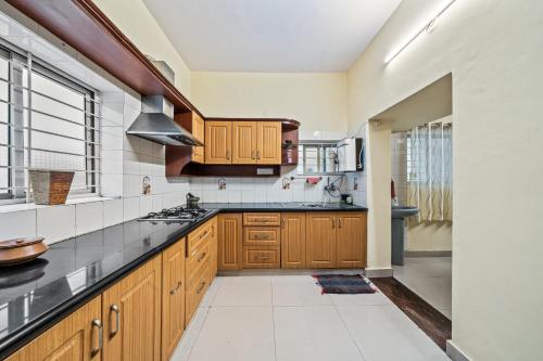 a kitchen with wooden cabinets and black counter tops at Ivory - Vintage Haven in Bangalore
