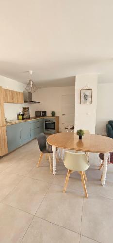 une cuisine et une salle à manger avec une table et des chaises en bois dans l'établissement La Cigale du Lubéron, à Beaumont-de-Pertuis