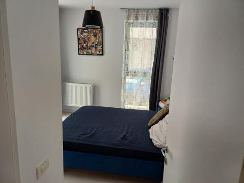 ママイア・ノルドにあるPanoramis Apartamentの青いベッドと窓のある寝室