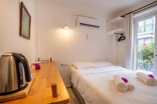 Schlafzimmer mit einem Bett, einem TV und einem Fenster in der Unterkunft Hideaway in Kaş