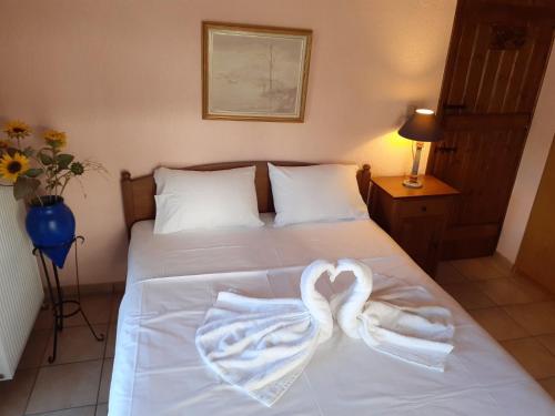 a bed with two towels in the shape of a heart at Nerotrivia stone house in Nerotriviá