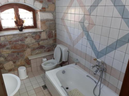 a bathroom with a tub and a toilet and a sink at Nerotrivia stone house in Nerotriviá