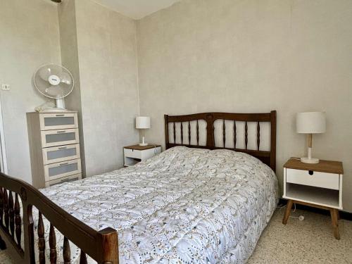 une chambre avec un lit avec deux tables de nuit et deux lampes dans l'établissement Appartement 2 pièces, balcon, proche plage et commerces, quartier calme - Argelès-sur-Mer - FR-1-225-685, à Argelès-sur-Mer