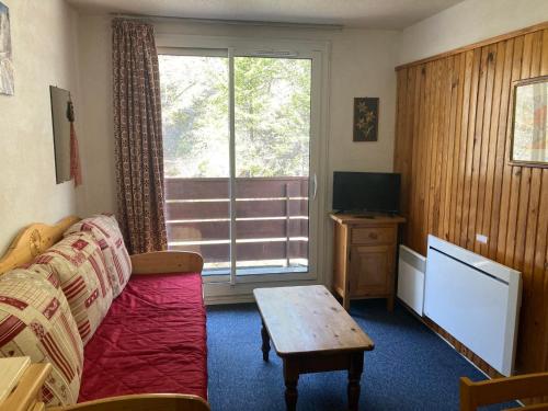 un salon avec un canapé, une table et une fenêtre dans l'établissement Studio cabine au Pleynet avec balcon, près des pistes - FR-1-557A-2, à La Ferrière