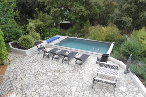un patio avec des chaises et une piscine dans l'établissement Appartement 55m2 dans villa avec piscine Valescure, à Saint-Raphaël