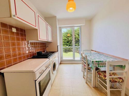 une cuisine avec une table, un évier et une cuisinière dans l'établissement Quiberon - 2 pièces - 52m² - Balcon côté mer - Animaux admis - FR-1-478-66, à Quiberon