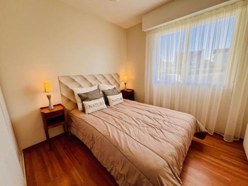 une chambre avec un lit avec deux oreillers dessus dans l'établissement Quiberon - appartement 3 pièces - 56m² - proche centre - garage - loggia - sans animaux - FR-1-478-99, à Quiberon