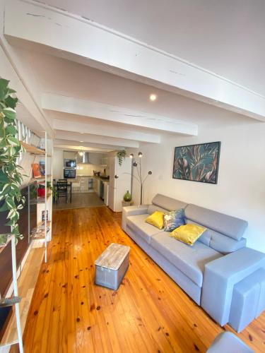 - un salon avec un canapé et du parquet dans l'établissement Maison de l'Ancienne Porte Neuve, à Narbonne