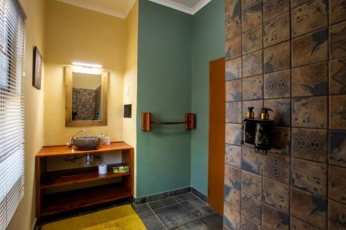y baño con lavabo y espejo. en Ijaba Lodge at Buschfeld Park, en Outjo