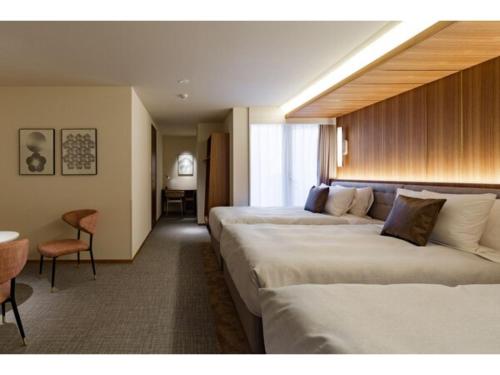 Habitación de hotel con 2 camas y mesa en The OneFive Terrace Fukuoka - Vacation STAY 33435v, en Fukuoka