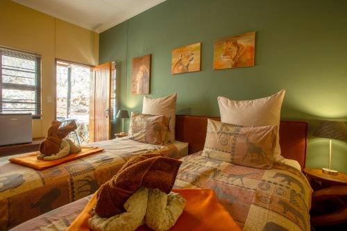 a bedroom with two beds with stuffed animals on them at Ijaba Lodge at Buschfeld Park in Outjo