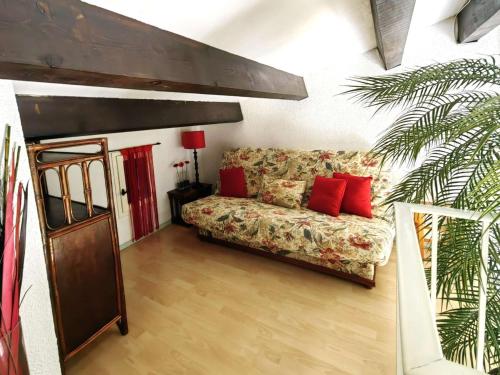 - un salon avec un canapé et des oreillers rouges dans l'établissement Villa calmes avec piscine et parking proche plage - FR-1-607-28, au Cap d'Agde