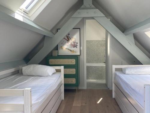 - une chambre mansardée avec 2 lits et une fenêtre dans l'établissement Longère rénovée proche Palais avec jardin, 5 chambres, 3 salles de bain, WIFI, idéale famille - FR-1-418-179, au Palais