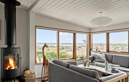 een woonkamer met een bank en een open haard bij 3 Bedroom Cozy Home In Juelsminde in Sønderby