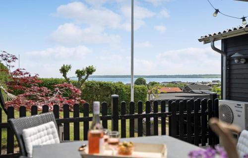 een tafel en stoelen op een balkon met uitzicht op de oceaan bij 3 Bedroom Cozy Home In Juelsminde in Sønderby