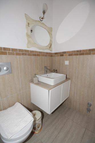 a bathroom with a sink and a toilet and a mirror at AlaNarin Konak in Alaçatı