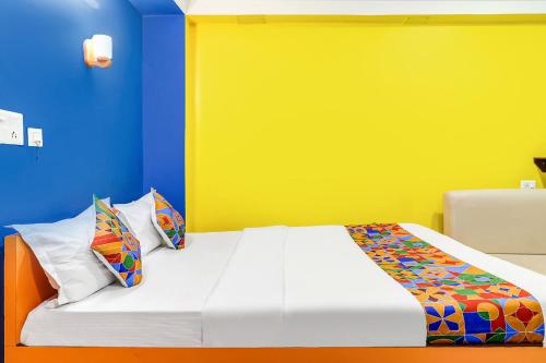 Bāghdogra的住宿－FabHotel Relax，一间卧室配有一张黄色和蓝色墙壁的床