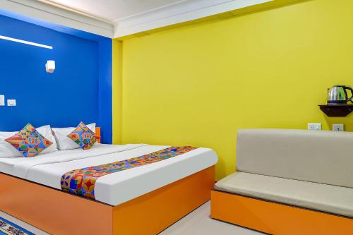 Bāghdogra的住宿－FabHotel Relax，一间卧室设有一张床,墙壁为蓝色和黄色